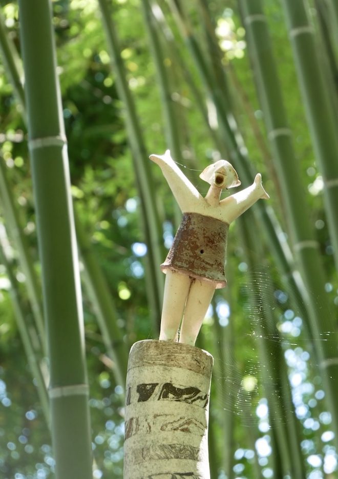 Installazione di una donna a braccia aperte in un boschetto di bambù