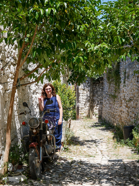 In un vicolo di Berat sotto un albero con una vecchia moto