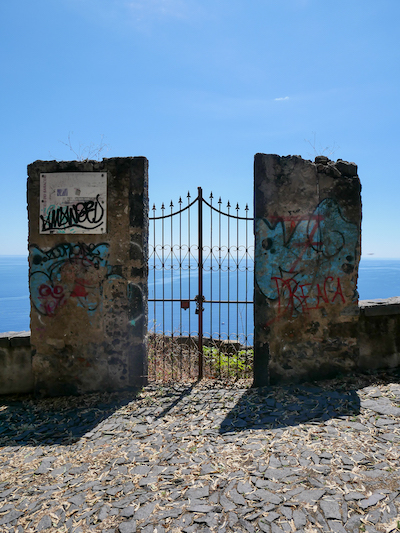 un punto molto instagrammabile sulla chiazzette per Santa Maria La Scala: un cancello che affaccia sul mare azzurrissimo, tra due ali di muro con dei disegni di Street Art