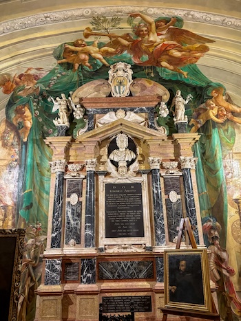 Il monumento funebre di Ludovico Ariosto alla Biblioteca Ariostea. Sal basamento di ergono 4 colonne corinzie che terminano con un frontone. Tutto di marmo colorato e e nero.
